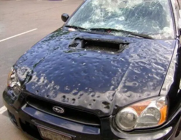 Car with extensive hail damage.