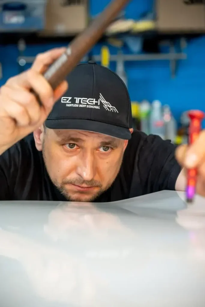 EZ Tech technician performing frame straightening with precision tools and equipment.