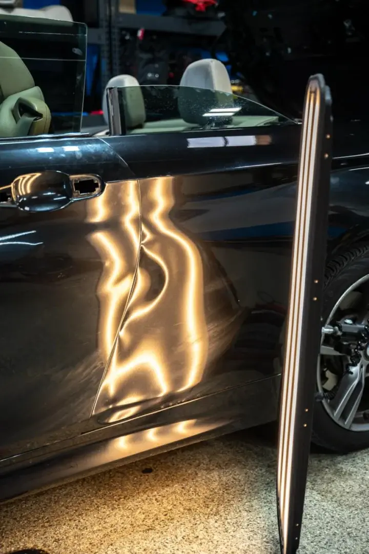 Paintless dent repair on car door showcasing factory finish restoration.