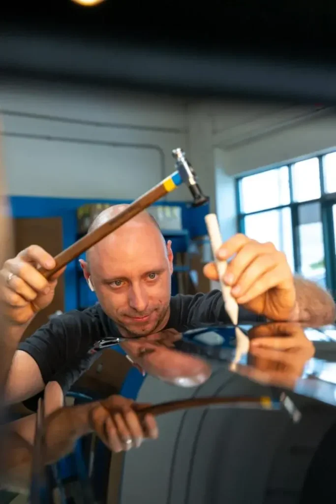 EZ Tech PDR technician repairing vehicle panel with specialized tools
