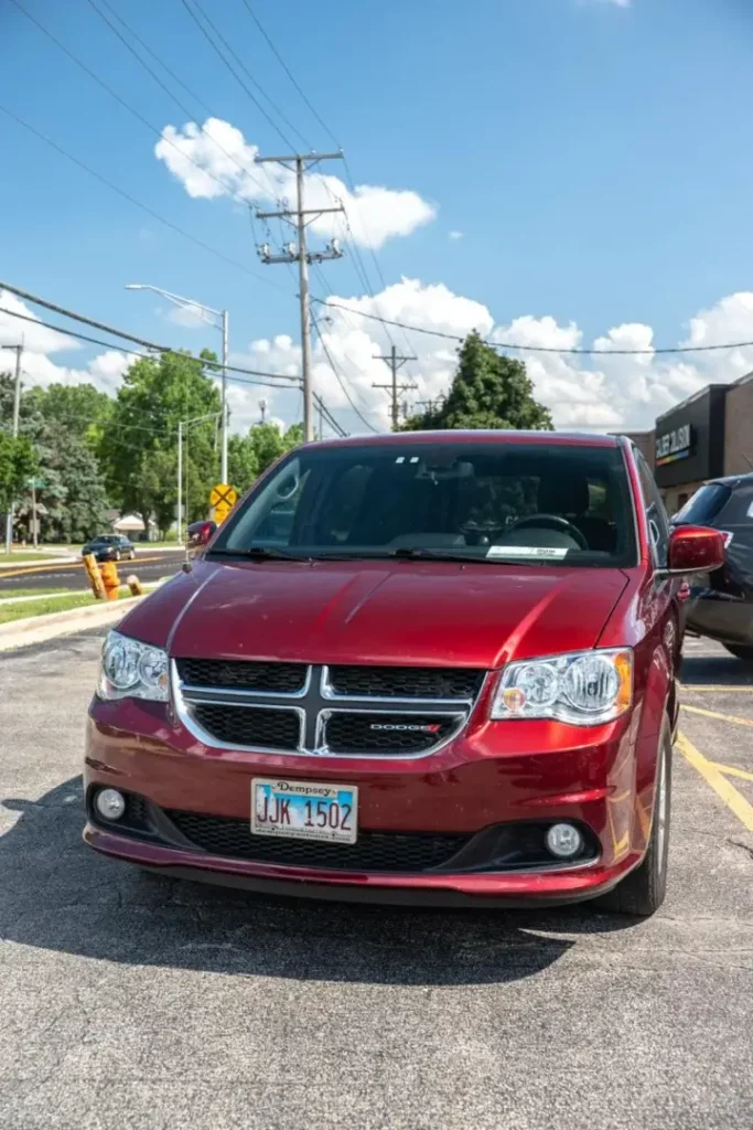 Red Dodge minivan after collision repair, showcasing EZ Tech PDR's restoration work.
