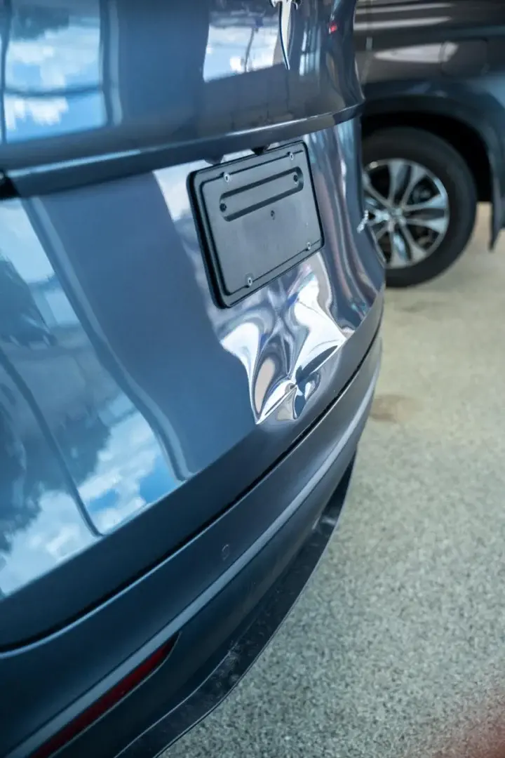 Gray SUV trunk dent repair demonstrating paintless dent removal process.