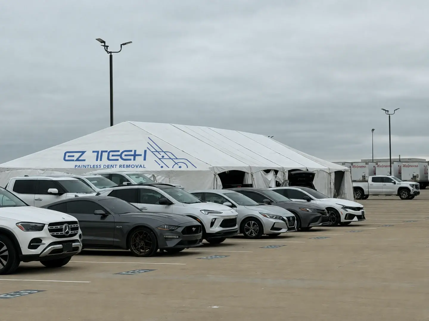 EZ Tech paintless dent removal tent with cars awaiting repair.