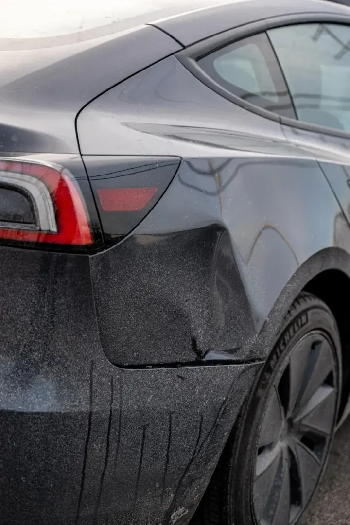 Black car with hail damage and fender dent repair needed