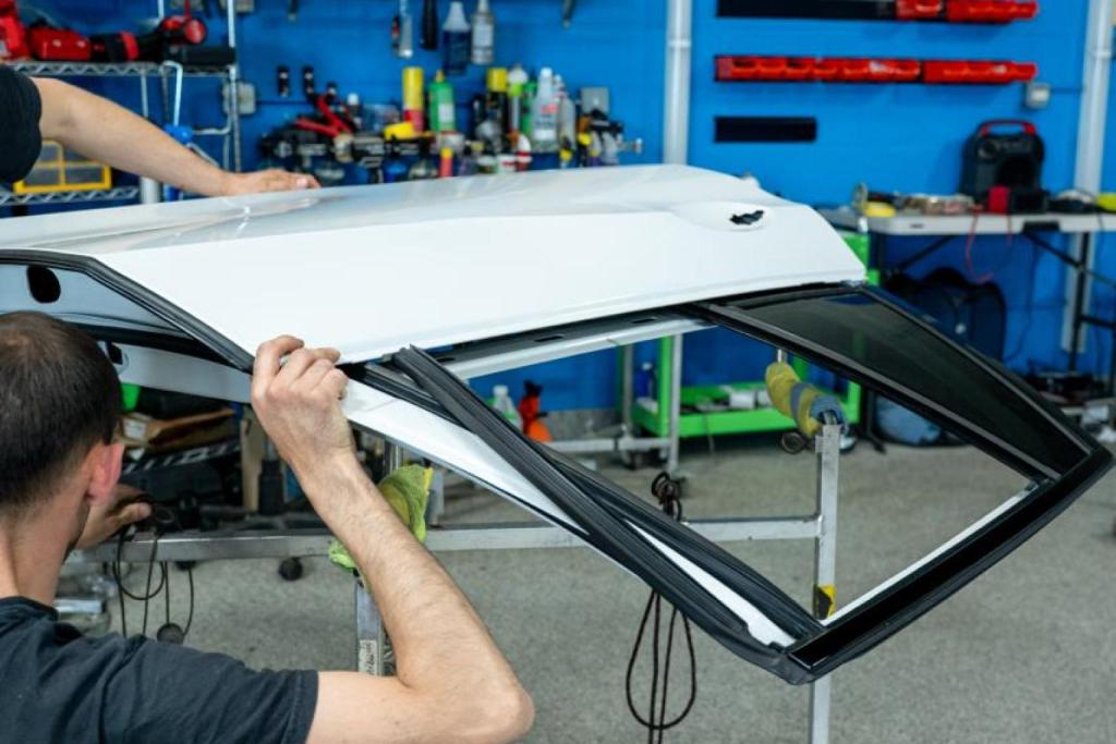 Hail damage repair process on white car panel in EZ Tech PDR shop.